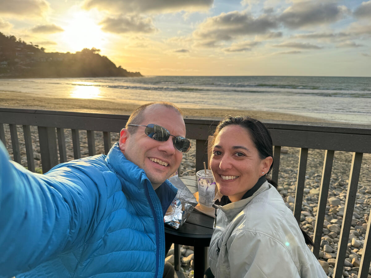 Michael and Michelle selfie with an ocean sunset in the background, on the beach.
