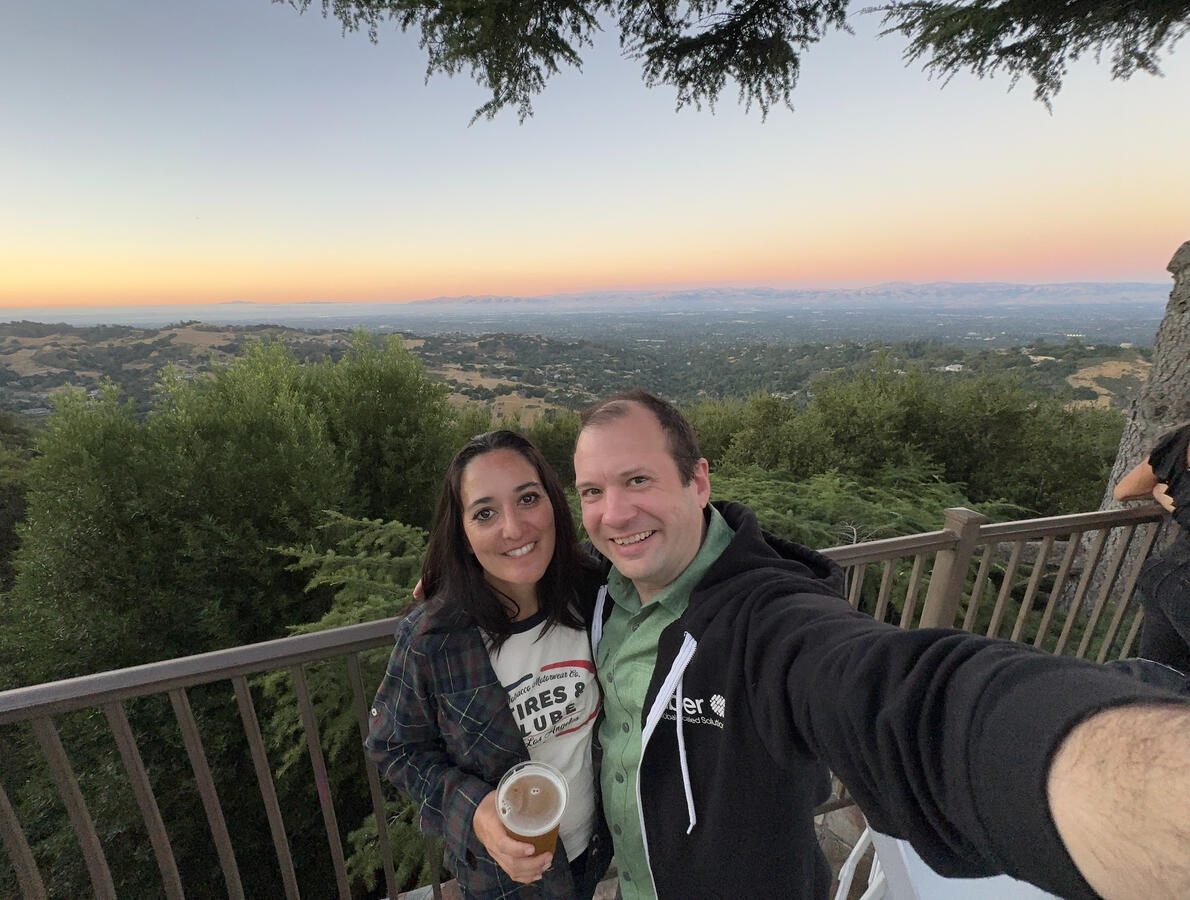 Untitled Michael and Michelle selfie with a sunset over land in the background, from high up.