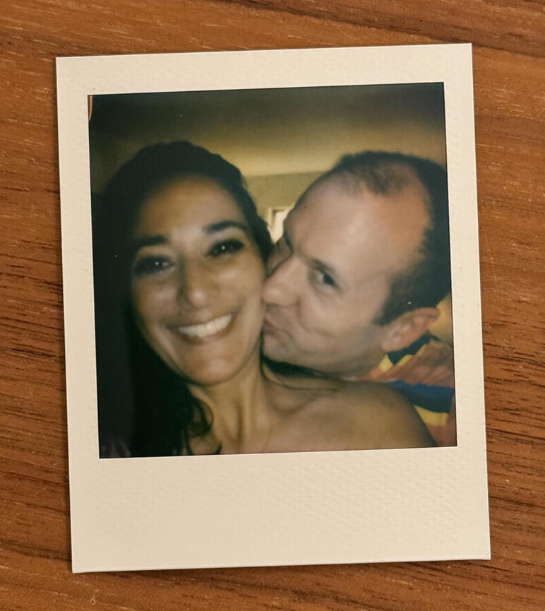 Polaroid picture of Michael kissing Michelle, flat on a wooden table. It's the source of the picture of them that was displayed on the satellite.